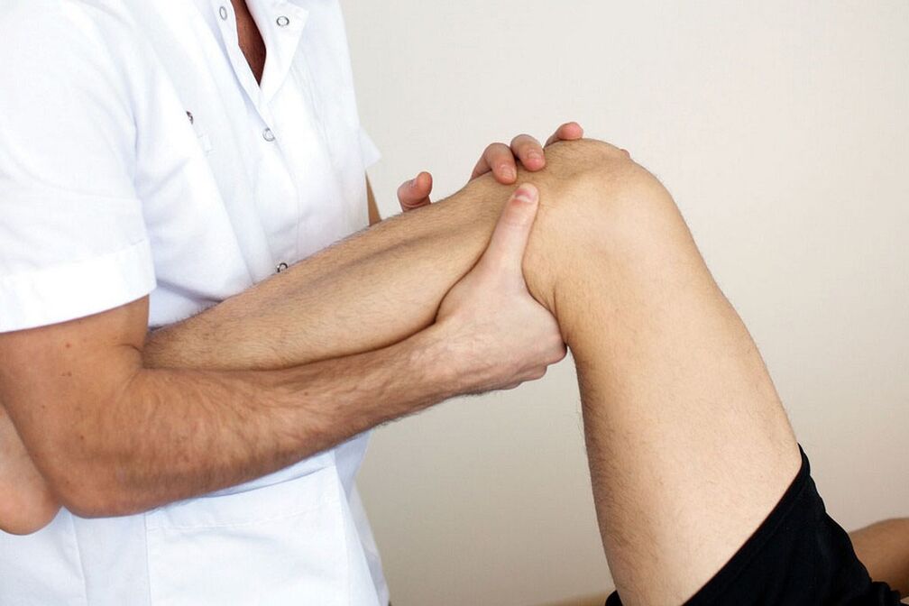Doctor examining knee with joint disease
